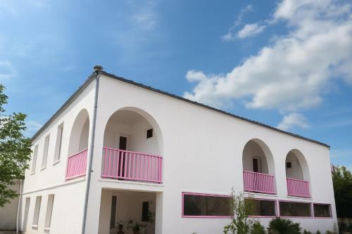 a white building with pink windows and a blue sky at flower land in Kutaisi