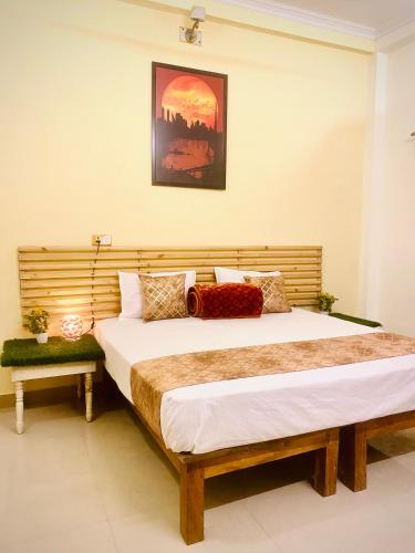 a bedroom with two beds and a picture on the wall at Rudra Homestay Varanasi in Varanasi