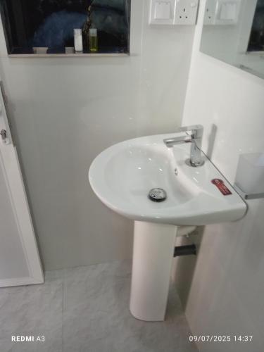 a bathroom with a white sink in a room at Solace Transit Villa in Katunayake