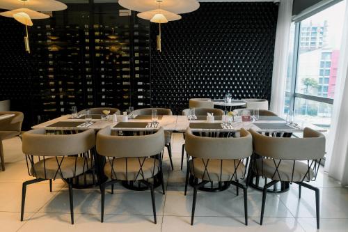 a dining room with a long table and chairs at The Residences at Novotel Tower in Manila