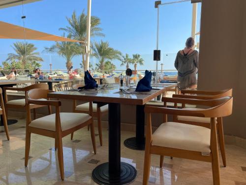 a woman standing in front of a table with chairs at Shams Prestige Abu Soma (Adults Only) in Hurghada
