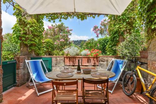 a patio with a table and chairs and a bike at Casa Gyotaku in Bagnaia