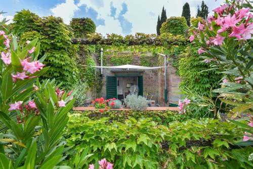a garden with pink flowers in front of a building at Casa Gyotaku in Bagnaia