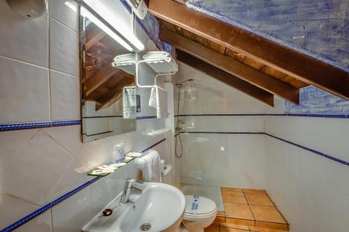 un baño con lavabo e inodoro en Hotel Rural Huerta del Laurel, en Monachil