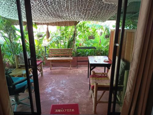 a living room with a table and chairs and a room with trees at Baan sikhao Yanui in Rawai Beach