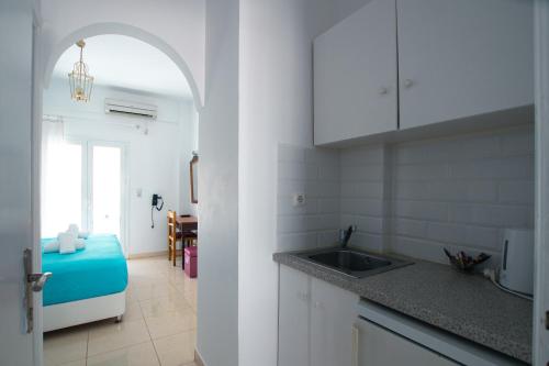 a kitchen with a sink and a room with a table at Pension Ptolemeos in Fira