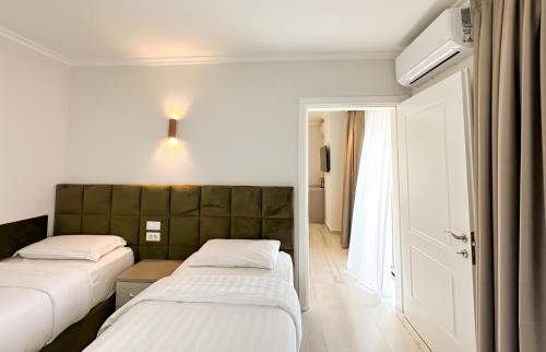 a hotel room with two beds and a door at Blumoon Holiday in Golem