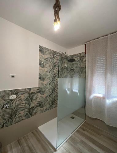 a bathroom with a glass shower with a wall at Ca' del Vento in Loreo