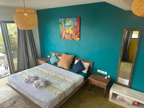 a bedroom with a bed and a blue wall at Le Refuge in Rodrigues Island