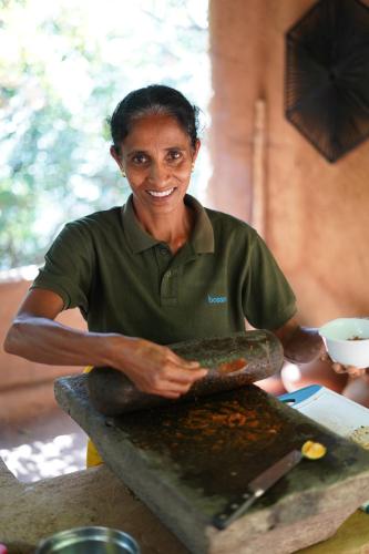 a woman is making food on a table at Nuga Retreat in Galauda