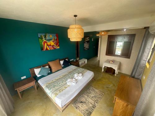 a bedroom with a bed and a green wall at Le Refuge in Rodrigues Island