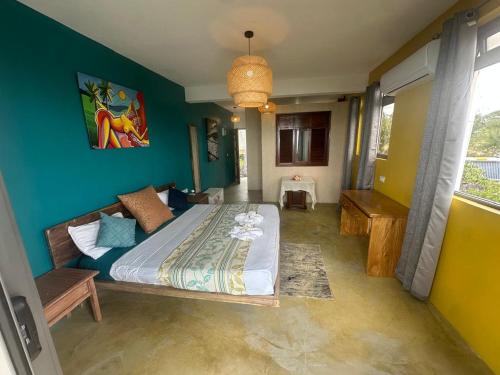 a bedroom with a bed and a blue wall at Le Refuge in Rodrigues Island