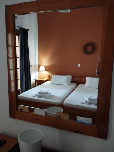 a mirror reflecting a bedroom with two beds in it at Sofia Apartments - Kantia in Kandia