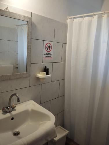 a bathroom with a sink and a shower curtain at Sofia Apartments - Kantia in Kandia
