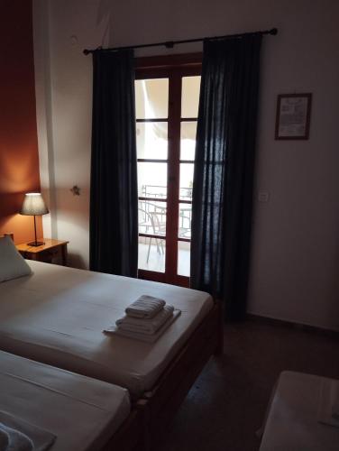 a bedroom with a bed and a window with towels on it at Sofia Apartments - Kantia in Kandia