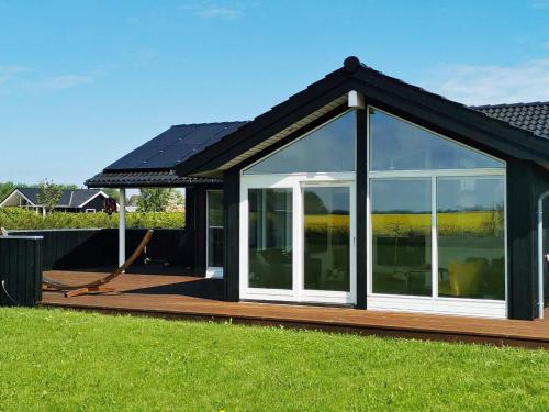 オテルプにある9 person holiday home in Otterup-By Traumの大きな窓のあるデッキ付きの家