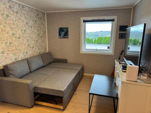 a living room with a couch and a window at Bergtun's Corner - Sotra Vest in Sekkingstad