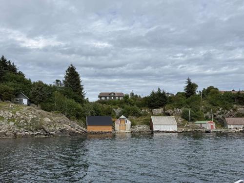 a group of houses on the shore of a body of water at Bergtun's Corner - Sotra Vest in Sekkingstad