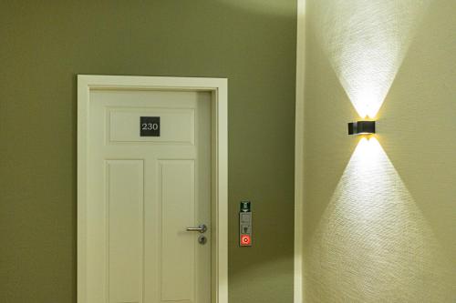 a door in a room with a light next to it at Romantik Hotel Walhalla in Osnabrück