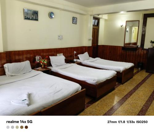 a room with three beds in a room at ARITHANG TASHI near M G marg in Gangtok