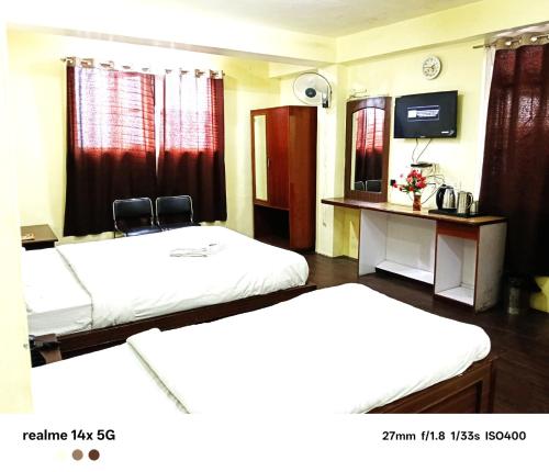 a hotel room with two beds and a television at ARITHANG TASHI near M G marg in Gangtok