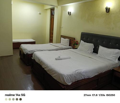 two beds in a hotel room with two bedsvisor at ARITHANG TASHI near M G marg in Gangtok