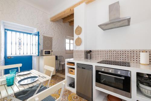 a kitchen with a stove top oven next to a table at Casa Al-Janda in Barbate