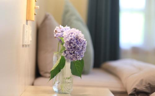 a vase of purple flowers sitting on a table at Floral Moganshan Natural Residence Pet Resort B&B in Huzhou