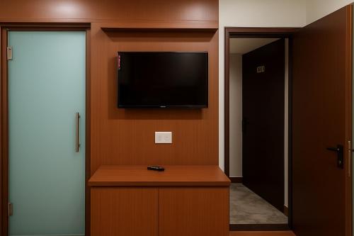 a room with a flat screen tv on a wall at Hotel Grand Lucent in Gokul