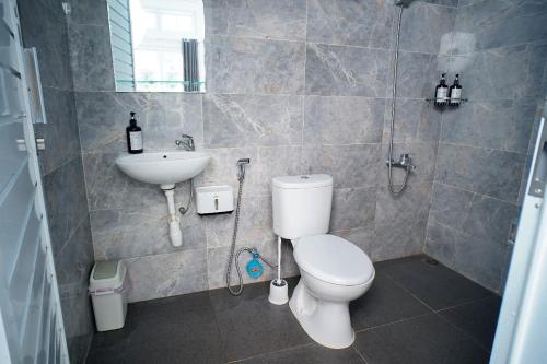 Un baño con un inodoro blanco y un lavabo. en Pilla Villa Purwokerto, en Purwokerto