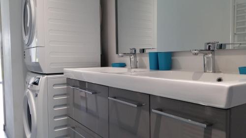 ein Badezimmer mit zwei Waschbecken und einem Kühlschrank in der Unterkunft le clos du fourmanoir in Avesnelles