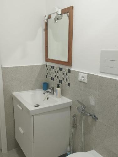 a bathroom with a sink and a mirror and a toilet at Casa Annina in Basilicata in Trivigno