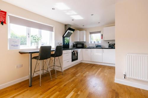 a kitchen with white cabinets and a table and chairs at James Ville Marina, Lodge 9 in Brigg
