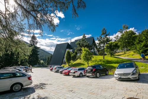 a parking lot with cars parked in front of a building at Pytloun Wellness Hotel Harrachov in Harrachov