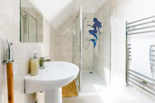 a bathroom with a sink and a shower with a mermaid sticker at James Ville Marina, Lodge 9 in Brigg