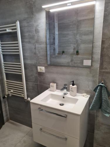 a bathroom with a white sink and a mirror at CityView Apartment in Arad