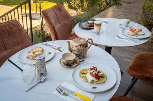 two white tables with plates of food on them at Aan d'Oewer in Citrusdal