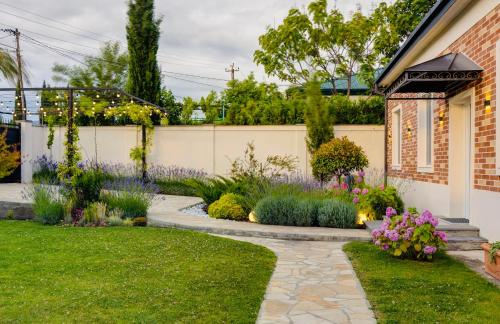 a garden with purple flowers and a walkway at Entire Villa Near Tbilisi Nature Reserve with Panoramic View in Mtskheta