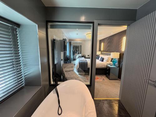 a bathroom with a bath tub and a bedroom at Ambleside Rooms & Suites in Ambleside