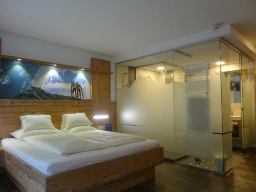 a bedroom with a bed and a glass wall at Hotel Gundolf in Sankt Leonhard im Pitztal