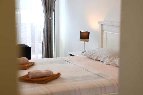a bedroom with a bed with two towels on it at Bright Modern Holiday Home With Postcard Lake View in Pluzine