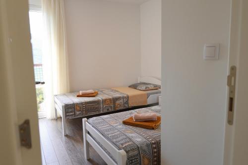 a room with two beds and a window at Bright Modern Holiday Home With Postcard Lake View in Pluzine
