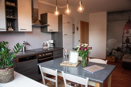 ノーヴァ・ポネンテにあるNock Apartment Dolomites in South Tyrol - Italyのキッチン(花のテーブル付)