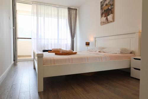a bedroom with a large bed with a window at Bright Modern Holiday Home With Postcard Lake View in Pluzine