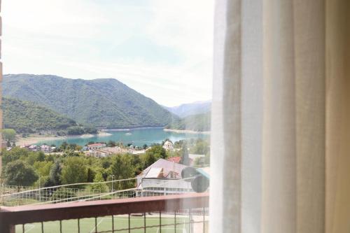 a room with a view of a lake and mountains at Bright Modern Holiday Home With Postcard Lake View in Pluzine