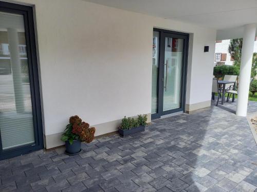 a patio with potted plants on the side of a house at Bergzauber Ofterschwang in Ofterschwang
