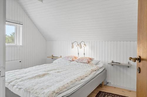 Un dormitorio blanco con una cama grande en un ático. en 20045-Ulfborg-Hummelmosevej-5, en Sundhuse