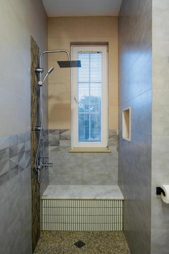 a shower stall in a bathroom with a window at Entire Villa Near Tbilisi Nature Reserve with Panoramic View in Mtskheta