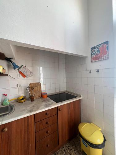 a kitchen with a sink and a yellow toilet at Solar Das Marés in Fuzeta