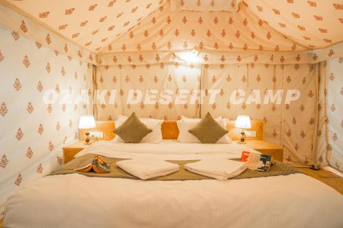 a bedroom with a bed with a sign that reads desert camp at Ozaki Desert Camp & Resort in Jaisalmer